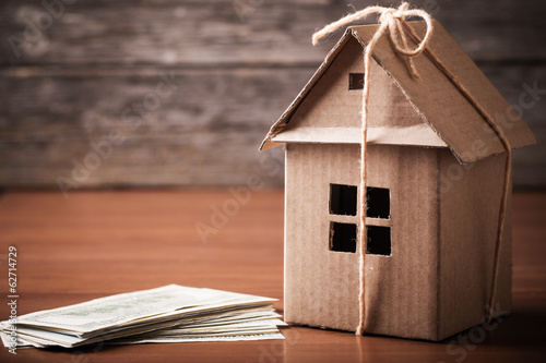 Photo: House from the paper and money on wooden background House from the paper and money on wooden background