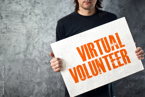 Photo: Man holding banner with VIRTUAL VOLUNTEER title Man holding banner with VIRTUAL VOLUNTEER title