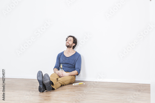 Photo: Mann sitzt auf dem Boden Mann sitzt auf dem Boden