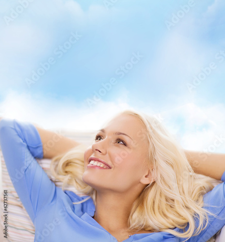 Photo: smiling young woman lying on sofa smiling young woman lying on sofa