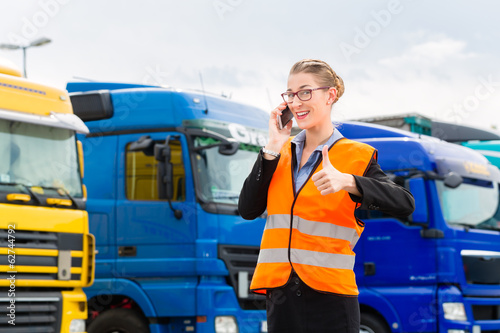 Photo: Spediteurin vor Lastwagen und LKW auf Depot Spediteurin vor Lastwagen und LKW auf Depot
