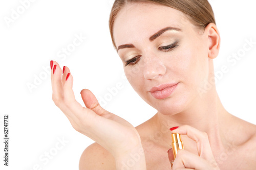 Photo: Young woman applying perfume isolated on white Young woman applying perfume isolated on white