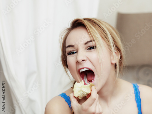 Photo: Blond woman teenage girl eating apple healthy fruit. Diet. Blond woman teenage girl eating apple healthy fruit. Diet.