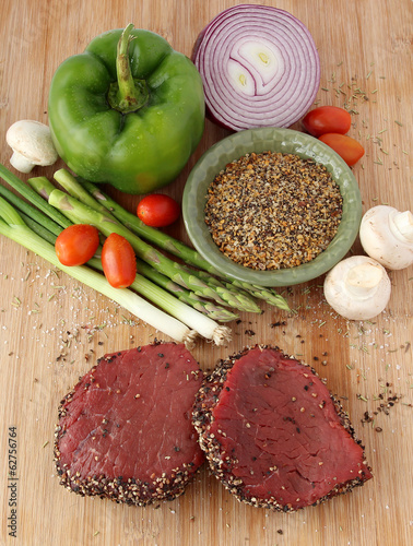 Photo: Raw steaks with vegetables and spices Raw steaks with vegetables and spices