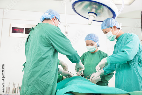 Photo: Team surgeon working in operating room. Team surgeon working in operating room.