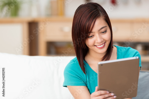 Photo: studentin liest zuhause am tablet-pc studentin liest zuhause am tablet-pc