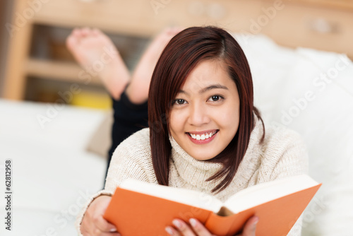 Photo: mädchen entspannt mit einem buch auf dem sofa mädchen entspannt mit einem buch auf dem sofa