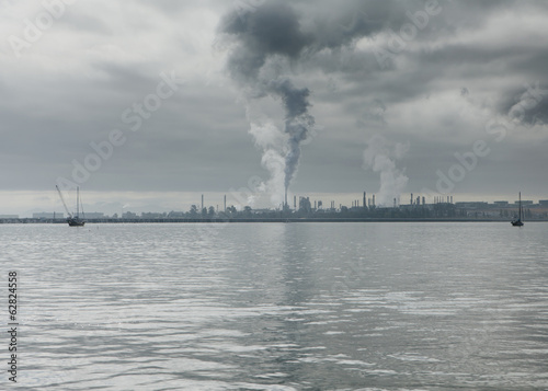Foto: Smoke from oil refinery rising towards sky at Anacortes in Puget Sound. Washington, USA Smoke from oil refinery rising towards sky at Anacortes in Puget Sound. Washington, USA