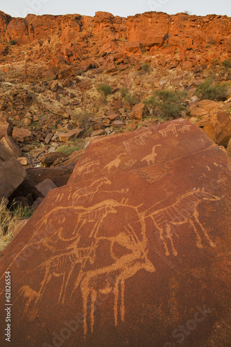 Photo: The ancient rock art carved on smooth sandstone at Twyfelfontein World Heritage Site at Uibasen Conservancy, Damaraland, Namibia. The ancient rock art carved on smooth sandstone at Twyfelfontein World Heritage Site at Uibasen Conservancy, Damaraland, Namibia.