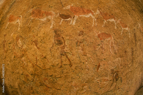 Photo: Close of the impressions, ancient rock art of animals and people made on the surface of the rock at Twyfelfontein World Heritage Site at Uibasen Conservancy, Damaraland, Namibia. Close of the impressions, ancient rock art of animals and people made on the surface of the rock at Twyfelfontein World Heritage Site at Uibasen Conservancy, Damaraland, Namibia.