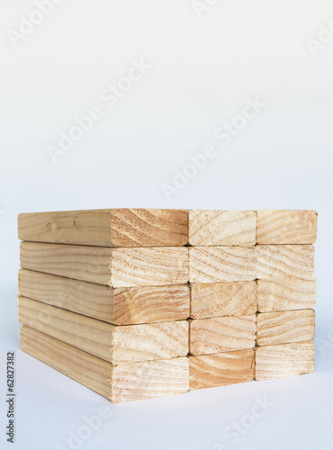 Foto: Stack of sawn prepared timber, spruce wood planks or studs, for use. Treated wood in traditional 2 by 4 measured cut shapes. Cut ends. Stack of sawn prepared timber, spruce wood planks or studs, for use. Treated wood in traditional 2 by 4 measured cut shapes. Cut ends.