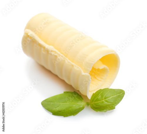 Photo: Curl of fresh butter with basil, isolated on white Curl of fresh butter with basil, isolated on white