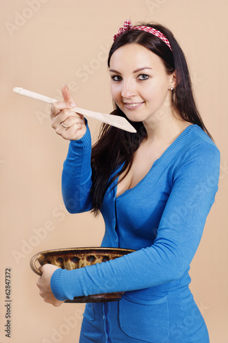 Photo: Beautiful woman with wooden cooking spoon Beautiful woman with wooden cooking spoon