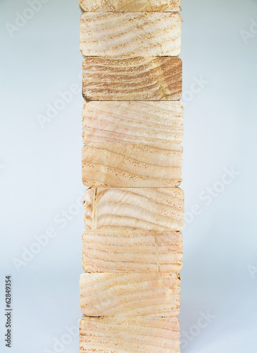 Foto: Stack of sawn prepared timber, spruce wood planks or studs, for use. Treated wood in traditional 2 by 4 measured cut shapes. Cut ends. Stack of sawn prepared timber, spruce wood planks or studs, for use. Treated wood in traditional 2 by 4 measured cut shapes. Cut ends.
