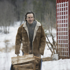 Photo: An organic farm in winter in New York State, USA. A man wheeling a barrow of firewood. An organic farm in winter in New York State, USA. A man wheeling a barrow of firewood.