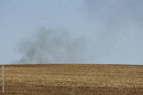 Foto: Smoke rising above a ridge, viewed across a ploughed field. Farmland near Pullman, Washington, USA Smoke rising above a ridge, viewed across a ploughed field. Farmland near Pullman, Washington, USA