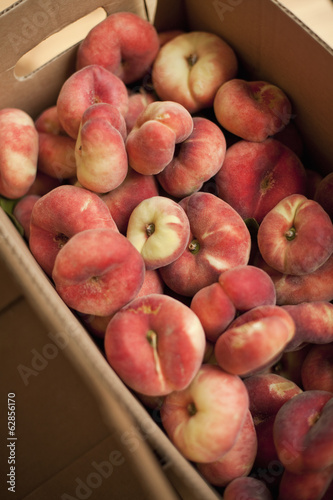 Photo: Fresh fruit on an organic farm stand. Doughnut peaches in a box. Fresh fruit on an organic farm stand. Doughnut peaches in a box.