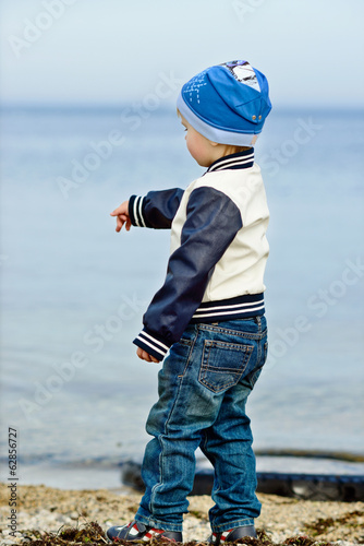 Photo: boy dropping stones in the sea boy dropping stones in the sea