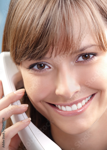 Photo: Young woman with phone, at office Young woman with phone, at office