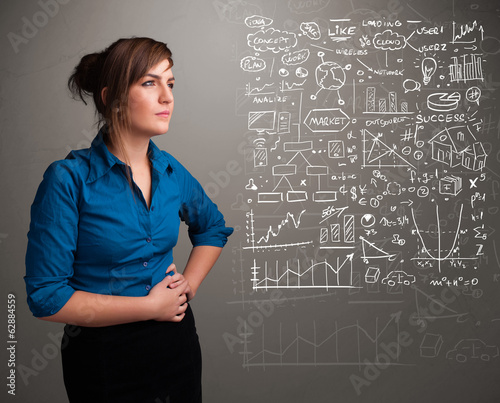 Photo: Pretty woman looking at stock market graphs and symbols Pretty woman looking at stock market graphs and symbols