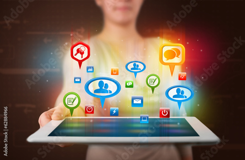 Photo: Girl presenting a tablet with colorful social icons and signs Girl presenting a tablet with colorful social icons and signs