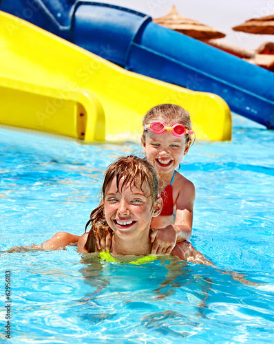Photo: Children on water slide at aquapark. Children on water slide at aquapark.