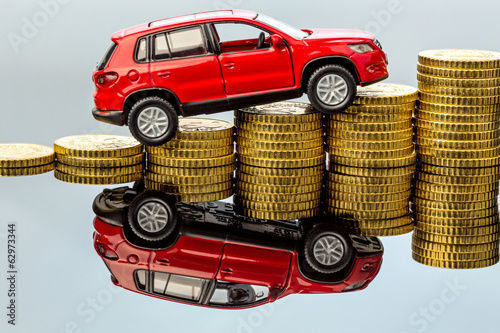 Photo: Steigende Autokosten. Auto auf Münzen Steigende Autokosten. Auto auf Münzen