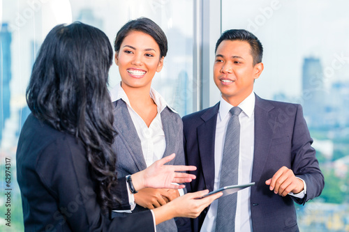 Photo: Asian Businesspeople standing in office Asian Businesspeople standing in office