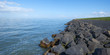 Dike with a stony shore along a lake in spring Dike with a stony shore along a lake in spring