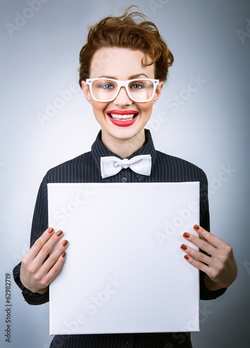 Photo: Cheerful young woman with blank white board Cheerful young woman with blank white board