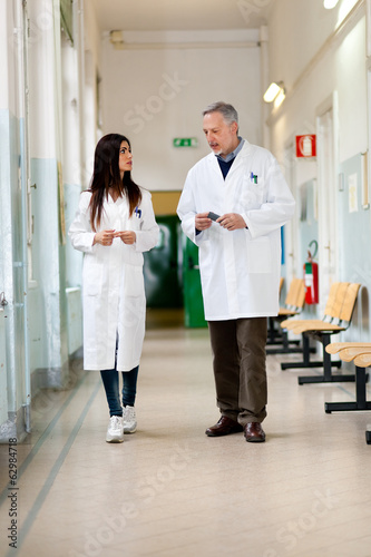Photo: Doctors talking in a hospital hallway Doctors talking in a hospital hallway