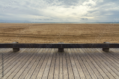 Photo: View of wooden passage in a long empty beach shoreline. View of wooden passage in a long empty beach shoreline.