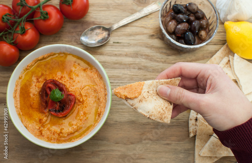Photo: dipping pita bread in hummus dipping pita bread in hummus