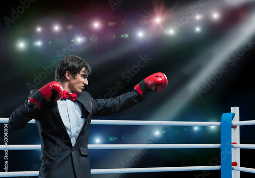 Photo: businessman with boxing gloves in the ring businessman with boxing gloves in the ring