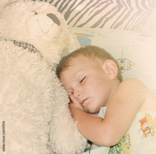 Photo: Cute little boy sleeping with his teddy bear Cute little boy sleeping with his teddy bear