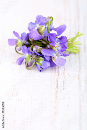 Photo: Violets flowers on wooden table Violets flowers on wooden table