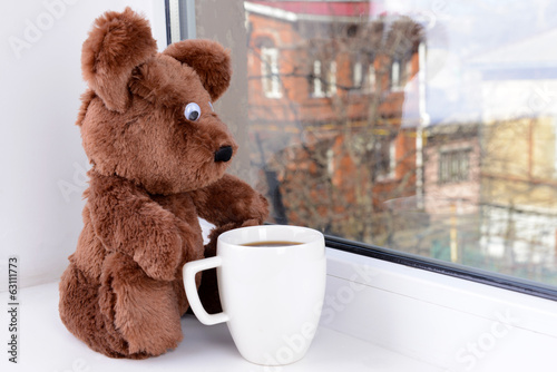 Photo: Toy-bear looking out window close-up Toy-bear looking out window close-up