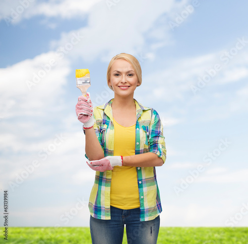 Photo: smiling woman with paintbrush smiling woman with paintbrush