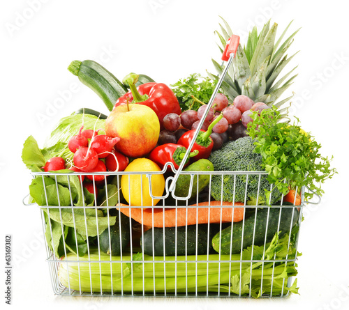 Photo: Wire shopping basket with groceries isolated on white Wire shopping basket with groceries isolated on white