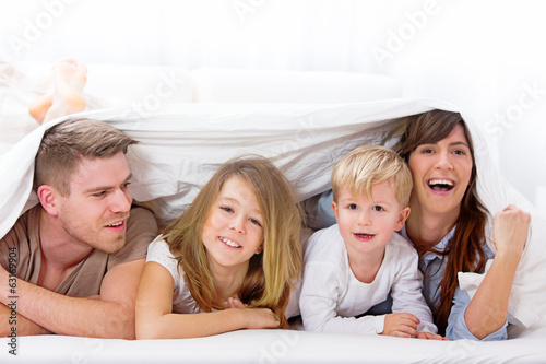 Photo: Familie unter der Decke zusammen Familie unter der Decke zusammen