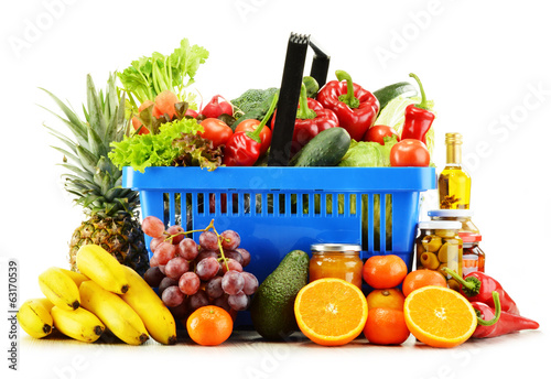 Photo: Plastic shopping basket with groceries isolated on white Plastic shopping basket with groceries isolated on white