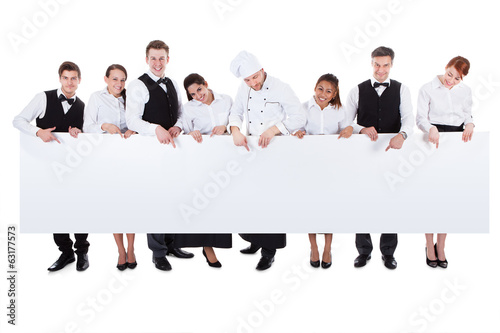 Photo: Group of catering staff holding a blank banner Group of catering staff holding a blank banner