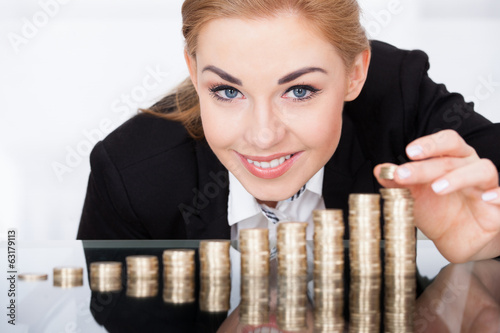 Photo: Businesswoman Stacking Coins Businesswoman Stacking Coins