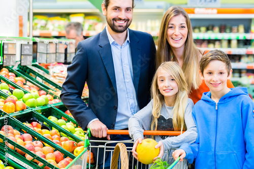 Photo: Famile beim Einkaufen im Lebensmittelmarkt Famile beim Einkaufen im Lebensmittelmarkt