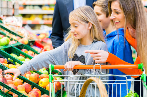 Photo: Famile beim Einkaufen im Lebensmittelmarkt Famile beim Einkaufen im Lebensmittelmarkt