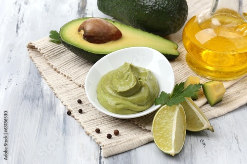 Photo: Fresh guacamole in bowl on wooden table Fresh guacamole in bowl on wooden table