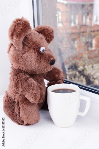 Photo: Toy-bear looking out window close-up Toy-bear looking out window close-up