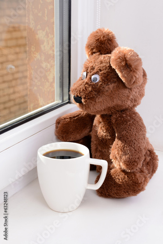 Photo: Toy-bear looking out window close-up Toy-bear looking out window close-up