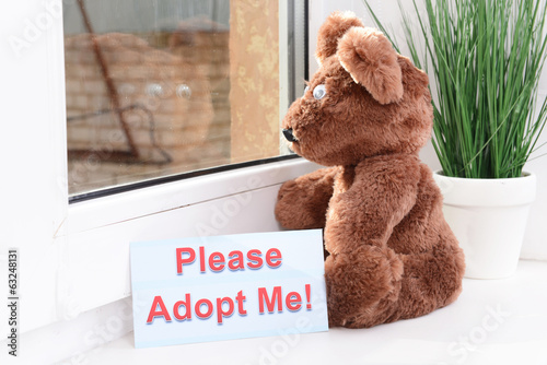 Photo: Toy-bear looking out window close-up Toy-bear looking out window close-up