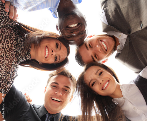 Photo: Low angle view of business people with their heads together Low angle view of business people with their heads together